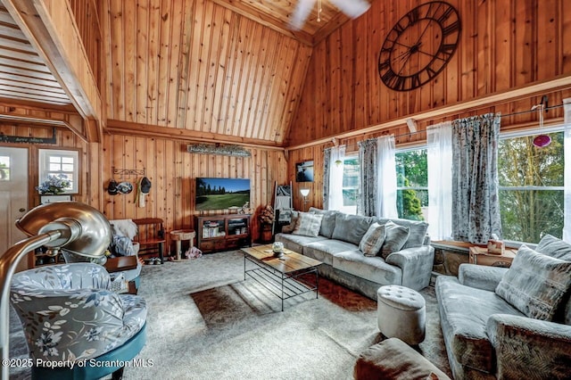 carpeted living room featuring high vaulted ceiling, wooden walls, and wood ceiling