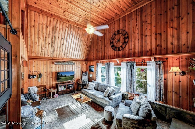 living room featuring a towering ceiling, carpet floors, wooden ceiling, ceiling fan, and wooden walls