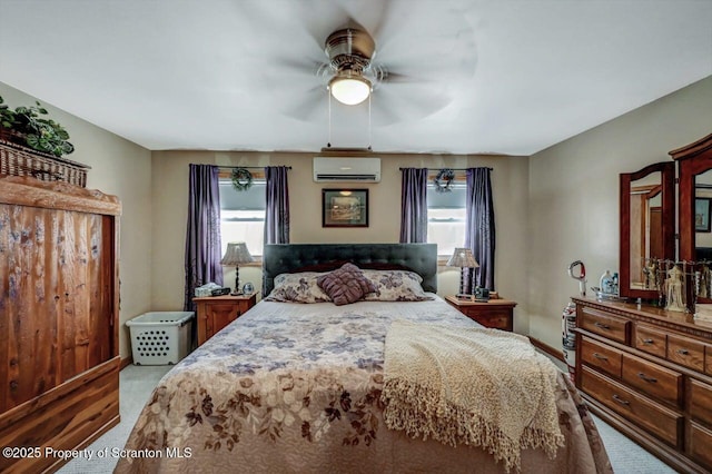 bedroom with ceiling fan, a wall unit AC, and light colored carpet