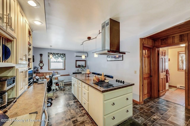 kitchen featuring cream cabinetry, a baseboard radiator, black electric cooktop, island range hood, and decorative light fixtures