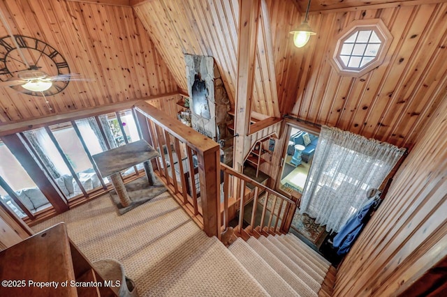 staircase featuring wooden walls and carpet flooring