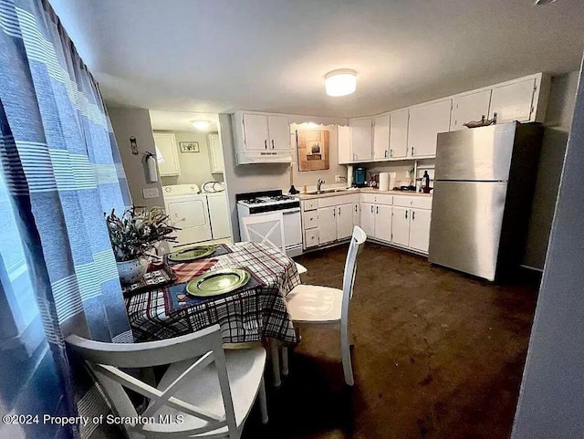 kitchen featuring washer and clothes dryer, white range, white cabinets, and stainless steel refrigerator