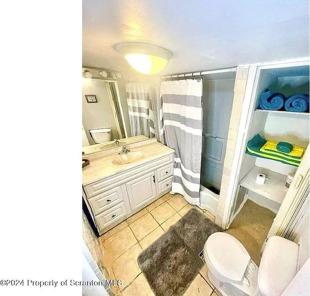 bathroom featuring tile patterned flooring, vanity, a shower with shower curtain, and toilet