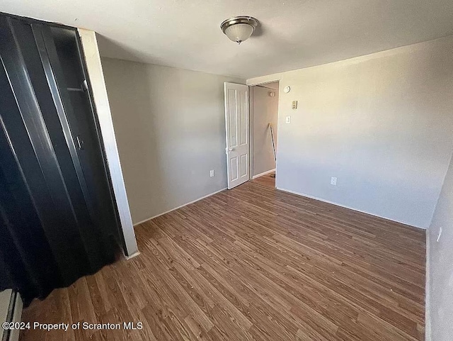 unfurnished bedroom with dark wood-type flooring