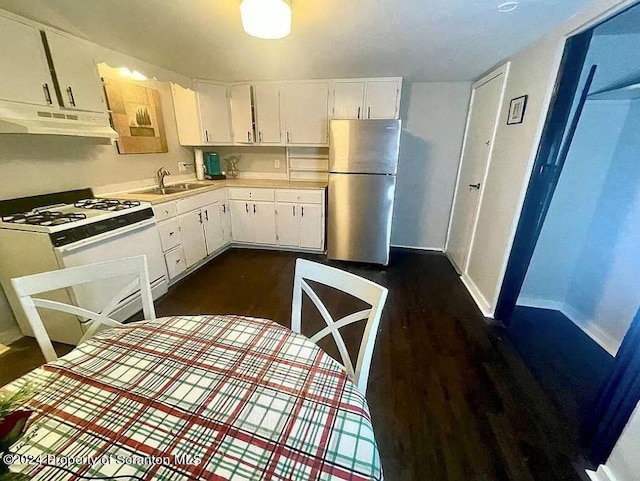 kitchen with stainless steel fridge, white cabinetry, gas range gas stove, and sink