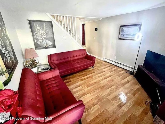 living room with wood-type flooring and a baseboard heating unit