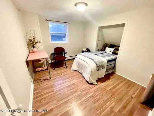 bedroom featuring hardwood / wood-style flooring and a baseboard radiator