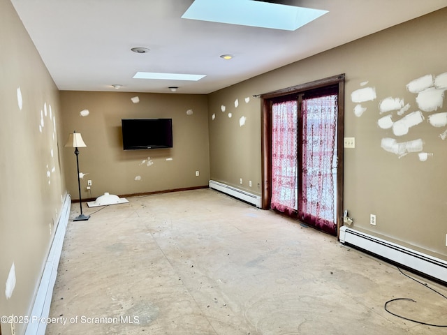 unfurnished living room featuring a skylight and a baseboard heating unit