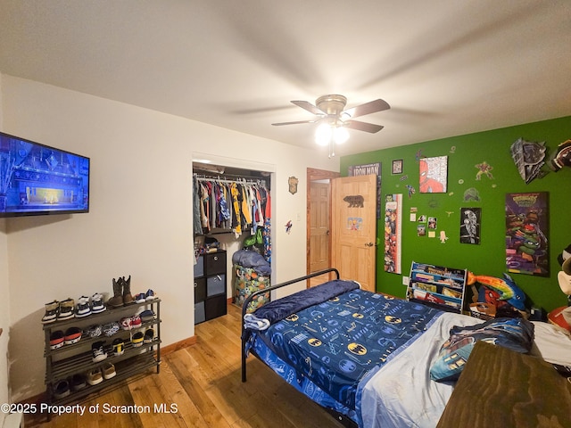 bedroom with hardwood / wood-style floors, ceiling fan, and a closet