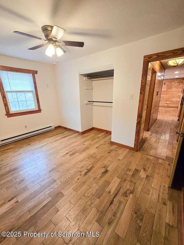 unfurnished bedroom with a closet, ceiling fan, light hardwood / wood-style floors, and baseboard heating