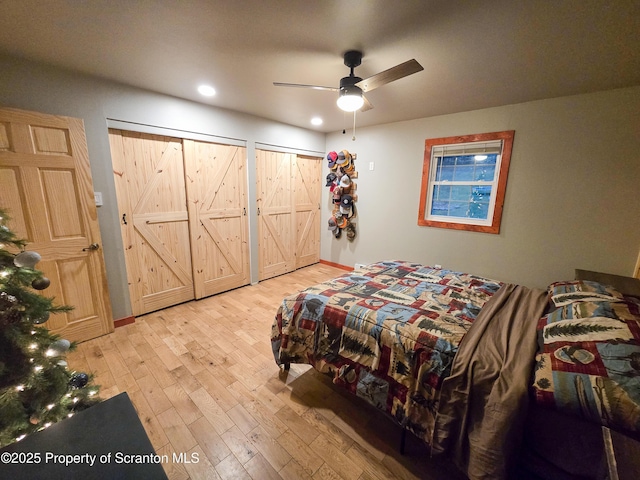 bedroom with multiple closets, ceiling fan, and light hardwood / wood-style flooring