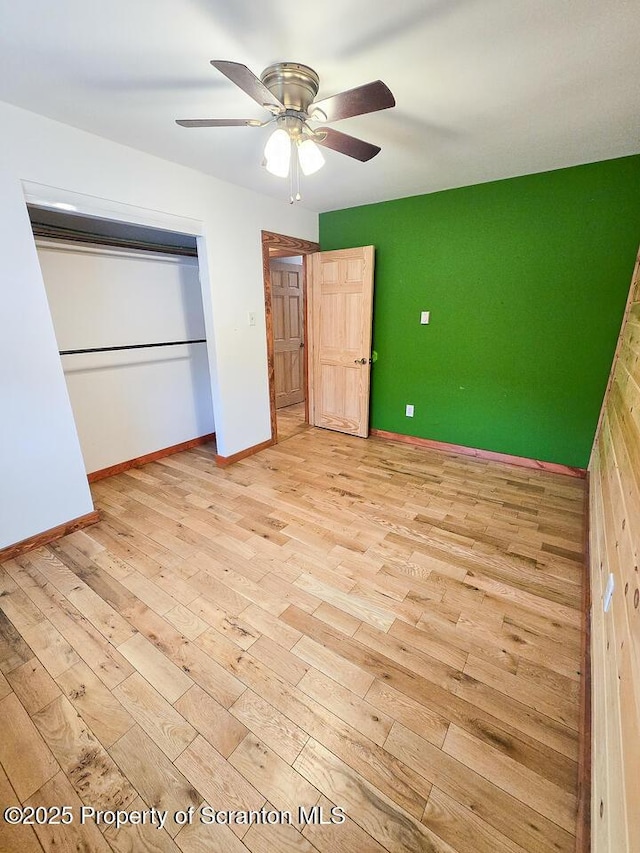 unfurnished bedroom with ceiling fan, light hardwood / wood-style floors, and a closet