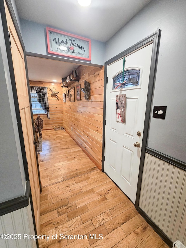 interior space with light hardwood / wood-style floors and wood walls