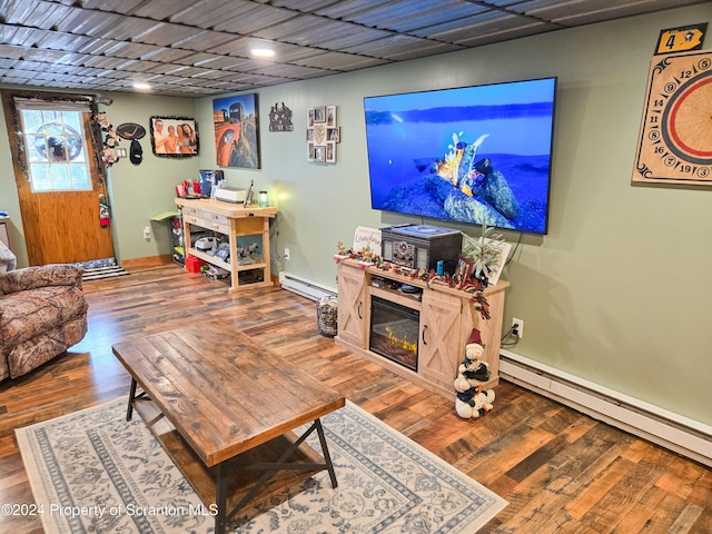 living room featuring a baseboard radiator, wood-type flooring, and a paneled ceiling