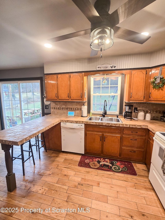 kitchen with sink, tasteful backsplash, ceiling fan, white appliances, and light hardwood / wood-style floors