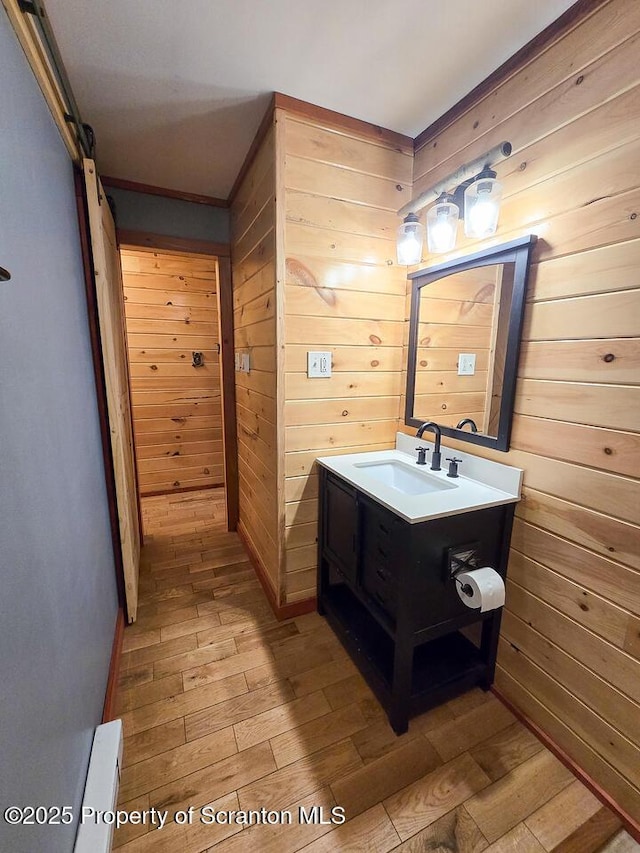 bathroom featuring hardwood / wood-style flooring, vanity, and wood walls