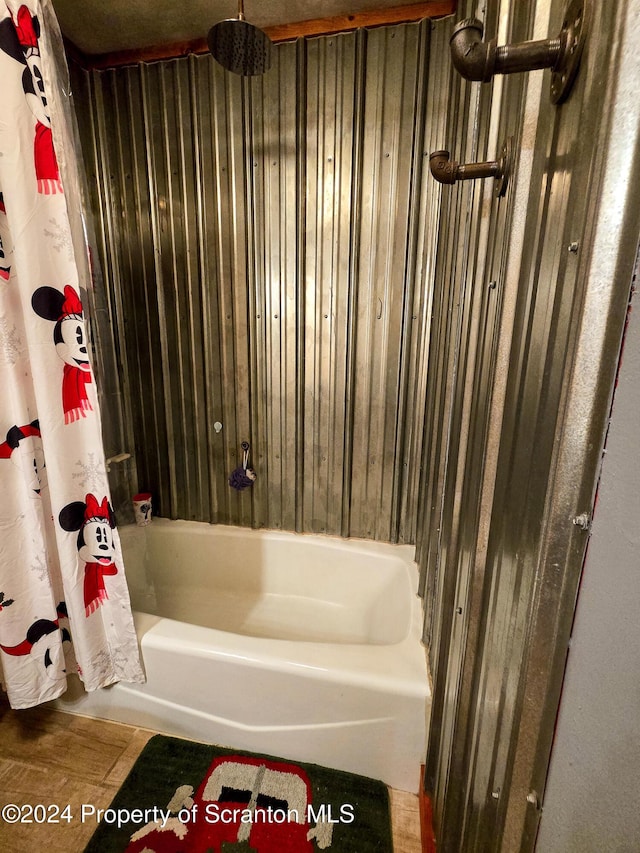 bathroom featuring shower / tub combo with curtain and wood walls