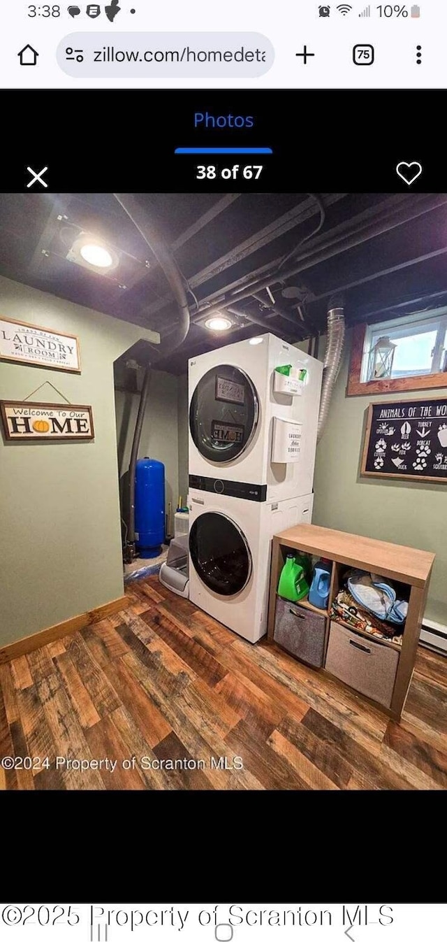 clothes washing area featuring wood-type flooring and stacked washer / drying machine