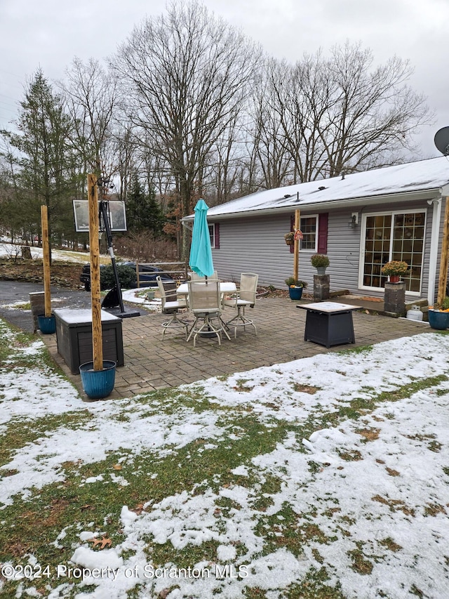 yard covered in snow with a patio