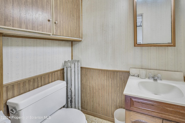 bathroom featuring vanity, toilet, and radiator heating unit