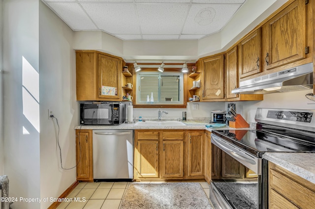 kitchen featuring a drop ceiling, light tile patterned flooring, sink, and appliances with stainless steel finishes