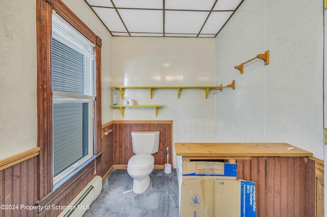 bathroom featuring a drop ceiling, a baseboard heating unit, and toilet