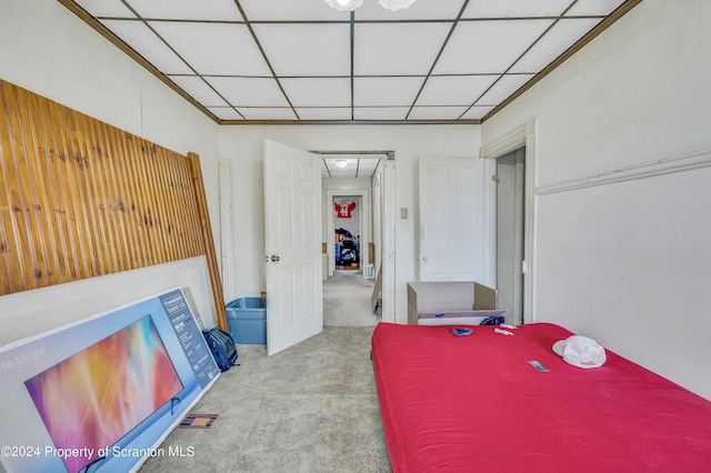 bedroom with light carpet and a paneled ceiling