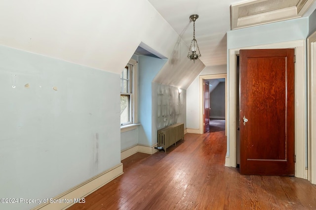 additional living space with lofted ceiling, dark hardwood / wood-style flooring, and radiator heating unit