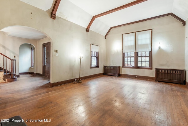 unfurnished living room with radiator heating unit, lofted ceiling, and hardwood / wood-style floors