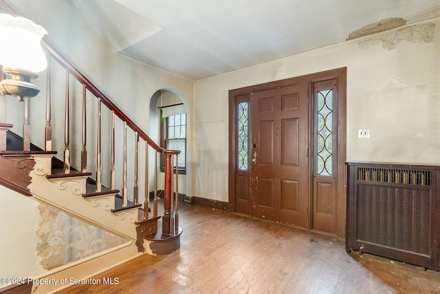 foyer entrance with hardwood / wood-style floors and radiator