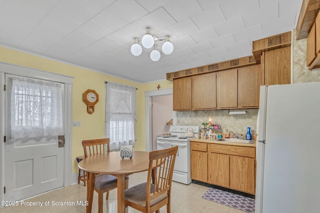 kitchen with sink, white appliances, and decorative backsplash