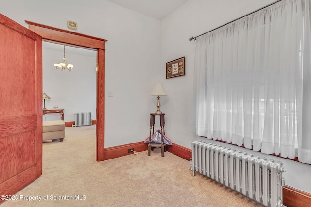 sitting room featuring a notable chandelier, carpet flooring, and radiator