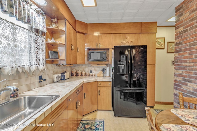 kitchen with sink, tile countertops, decorative backsplash, and black appliances