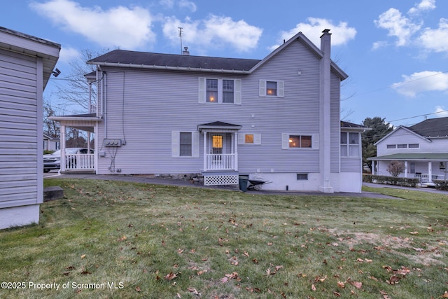 back of property featuring a lawn