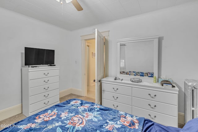 carpeted bedroom featuring ceiling fan and ornamental molding