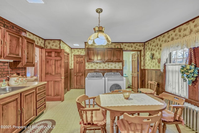 dining area with sink, crown molding, independent washer and dryer, and radiator