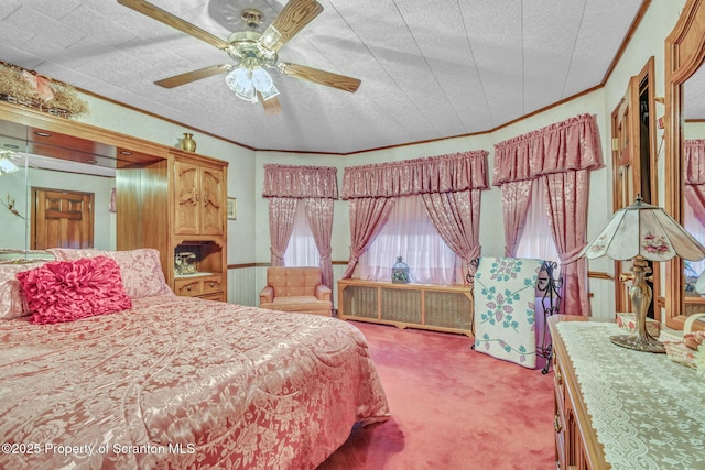 carpeted bedroom featuring a textured ceiling, ceiling fan, and ornamental molding