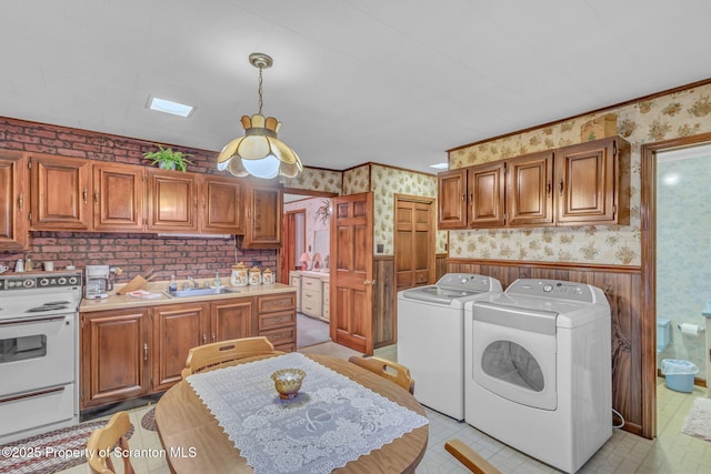 laundry area with sink, washing machine and clothes dryer, and ornamental molding