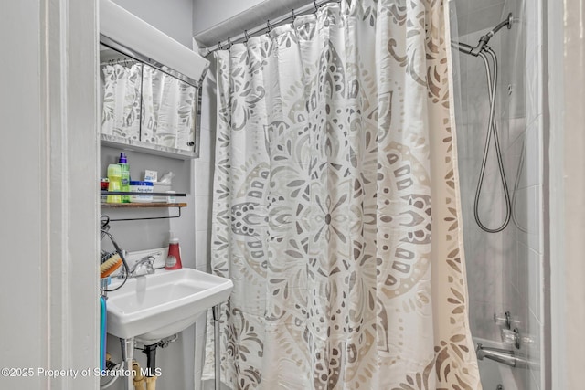 bathroom featuring shower / tub combo with curtain and sink