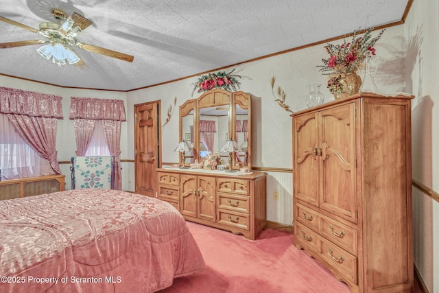 carpeted bedroom featuring ceiling fan, ornamental molding, and a textured ceiling