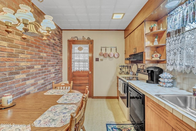 kitchen featuring sink, dishwasher, tile counters, brick wall, and range with electric stovetop