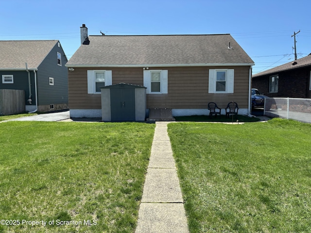 back of property featuring a lawn, fence, and roof with shingles