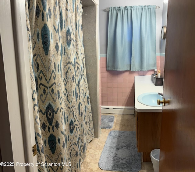 full bathroom with tile patterned flooring, a wainscoted wall, vanity, tile walls, and a baseboard radiator