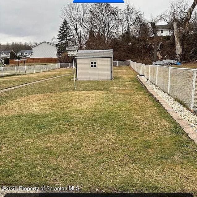 view of yard with an outdoor structure, a shed, and a fenced backyard