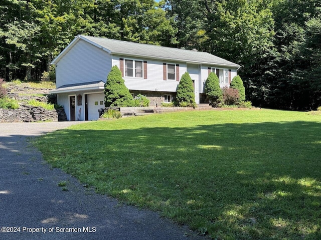 bi-level home featuring a garage and a front lawn