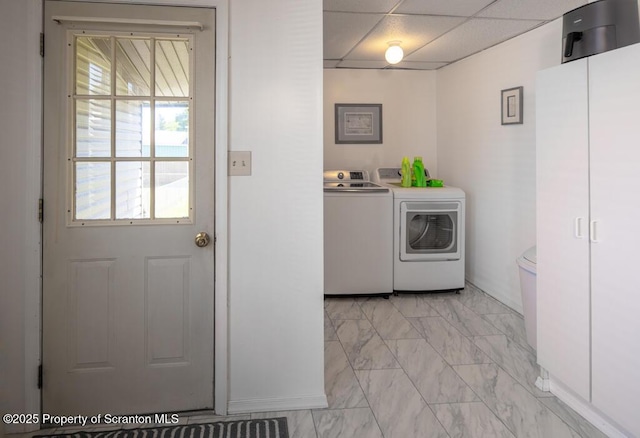 laundry area with washer and dryer and light marble finish floors