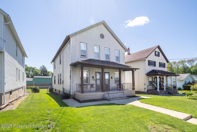 rear view of property with covered porch and a lawn