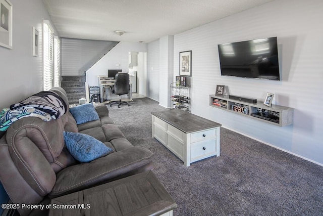 living room with dark carpet, a desk, and baseboards
