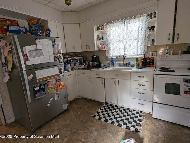 kitchen featuring white cabinetry, sink, electric range, backsplash, and stainless steel fridge