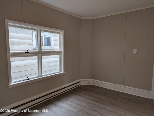 spare room featuring wood-type flooring, a baseboard radiator, and ornamental molding